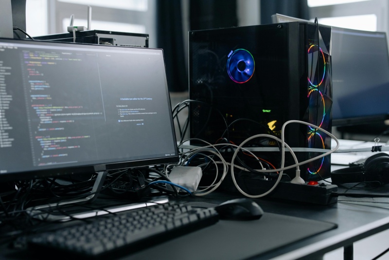 PC-Setup mit vielen Kabeln, am Bildschirm ist ein HTML-Code zu sehen