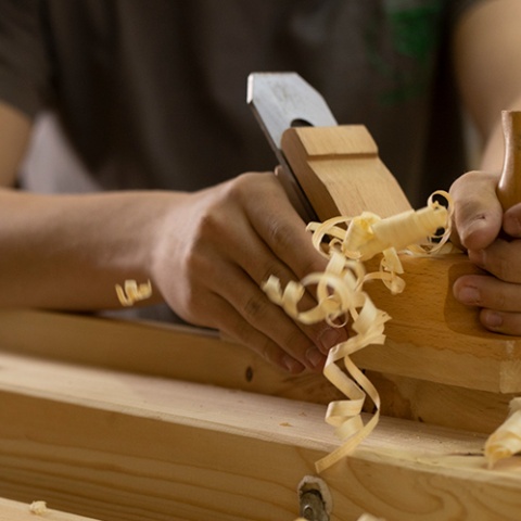 Ein Stück Holz wird gehobelt